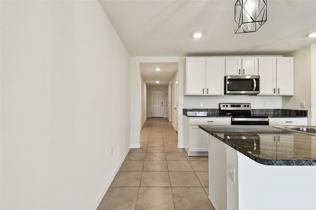 4918 Gray Owl Ter, Palmetto, FL 34221 - kitchen featuring appliances with stainless steel finishes, white cabinets, light tile patterned flooring, recessed lighting, and dark stone counters