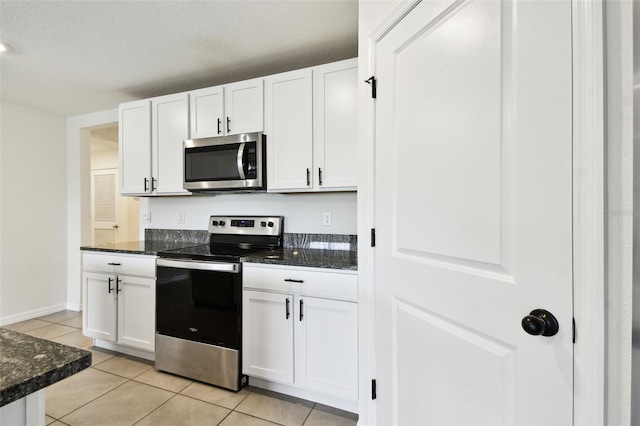 4918 Gray Owl Ter, Palmetto, FL 34221 - kitchen featuring stainless steel appliances, white cabinetry, light tile patterned flooring, and dark stone counters