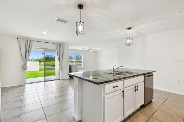 4918 Gray Owl Ter, Palmetto, FL 34221 - kitchen featuring stainless steel dishwasher, light tile patterned floors, white cabinets, hanging light fixtures, and dark stone counters