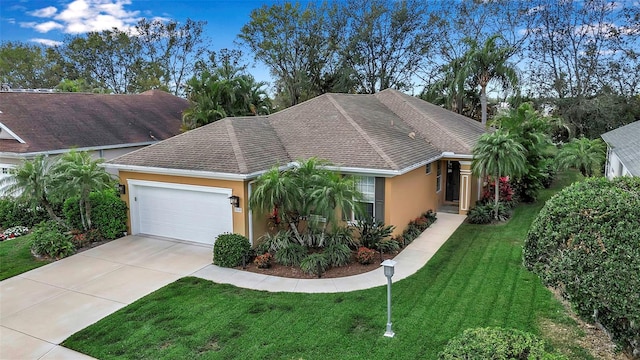 ranch-style house with concrete driveway, a shingled roof, a front yard, and stucco siding