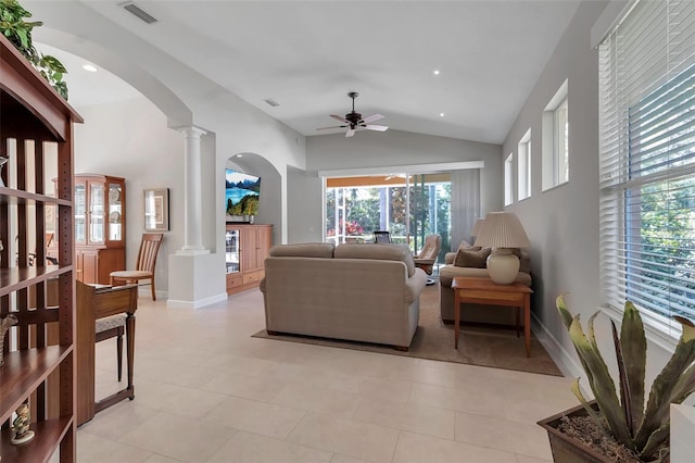 living area featuring decorative columns, baseboards, visible vents, arched walkways, and a ceiling fan