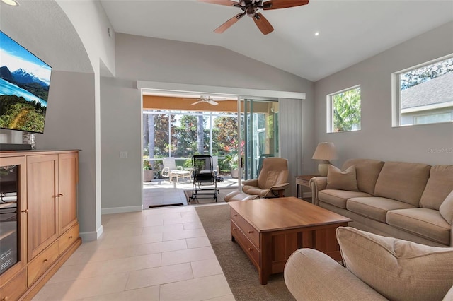 living room with lofted ceiling, ceiling fan, baseboards, and light tile patterned floors