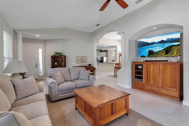 living room with ceiling fan, visible vents, baseboards, vaulted ceiling, and decorative columns