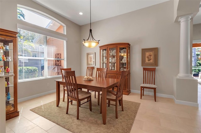 dining room featuring ornate columns, light tile patterned floors, and baseboards