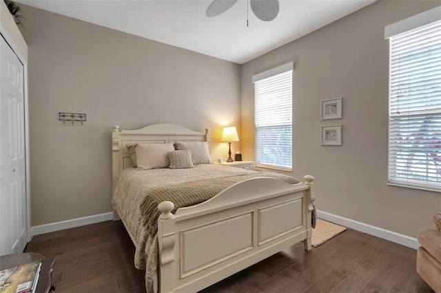 bedroom featuring a closet, baseboards, dark wood finished floors, and a ceiling fan