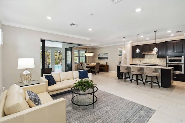 living area featuring recessed lighting, visible vents, and crown molding