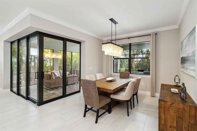 dining area with ornamental molding, a chandelier, and baseboards