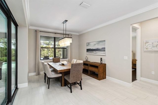 dining area with baseboards, a chandelier, visible vents, and crown molding