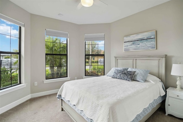 bedroom with a ceiling fan, carpet, multiple windows, and baseboards