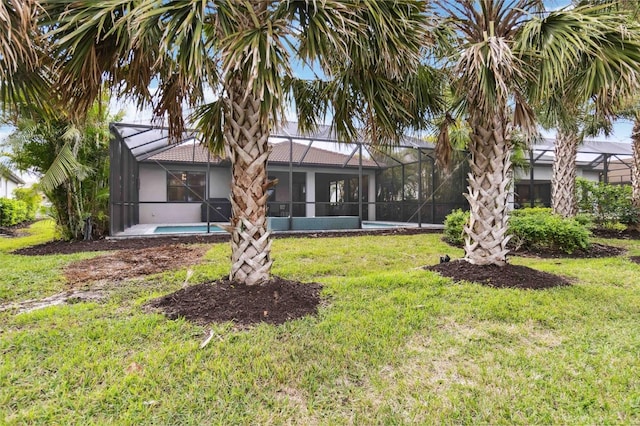 rear view of house featuring a yard and a lanai