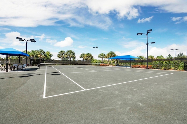 view of tennis court featuring fence