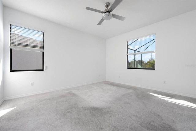 carpeted spare room with baseboards and ceiling fan