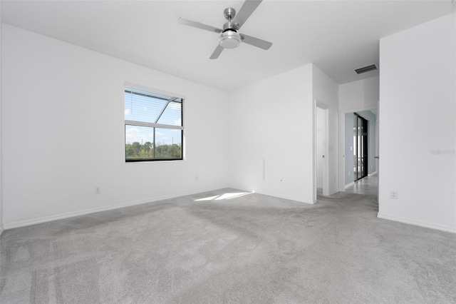 carpeted spare room featuring visible vents, baseboards, and a ceiling fan