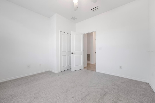 unfurnished bedroom featuring light carpet, visible vents, and baseboards