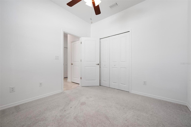 unfurnished bedroom featuring a ceiling fan, visible vents, baseboards, a closet, and light colored carpet