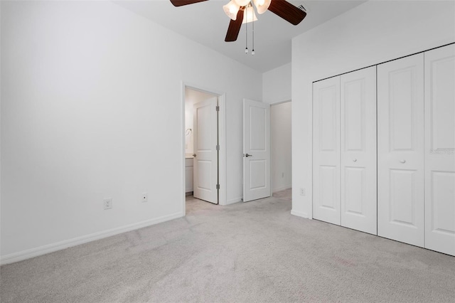 unfurnished bedroom with baseboards, carpet floors, ceiling fan, a closet, and ensuite bathroom