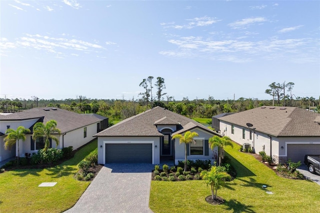 single story home with stucco siding, an attached garage, decorative driveway, and a front lawn