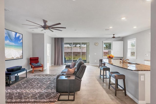 living room featuring recessed lighting, a ceiling fan, and baseboards