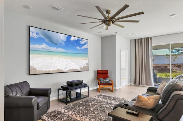 interior space featuring a ceiling fan, baseboards, visible vents, and a textured ceiling