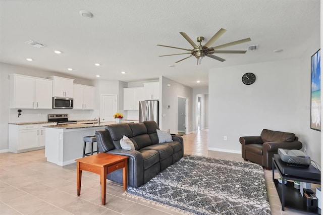 living area featuring recessed lighting, visible vents, and baseboards