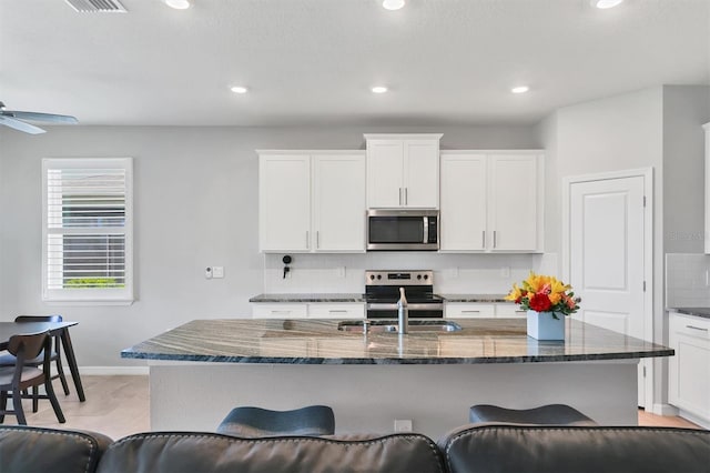 kitchen with tasteful backsplash, a breakfast bar area, stainless steel appliances, and a sink