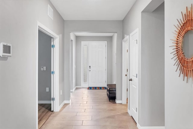 entrance foyer with light wood-style flooring, visible vents, and baseboards