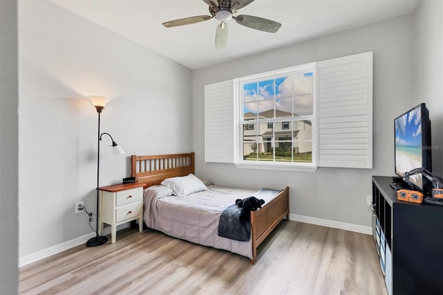 bedroom featuring light wood-style floors, baseboards, and a ceiling fan