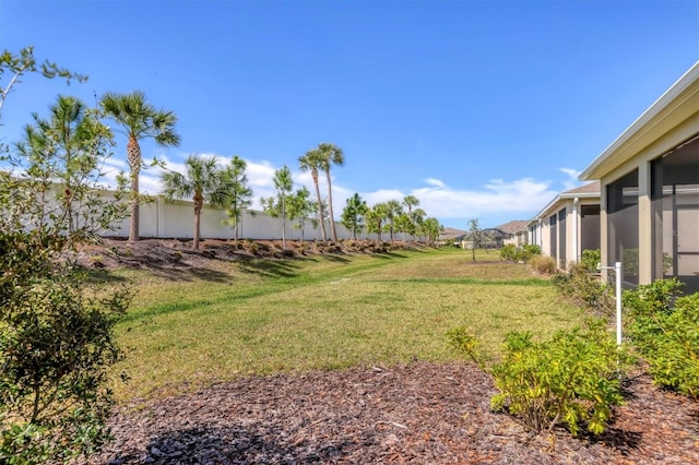 view of yard featuring a sunroom and fence