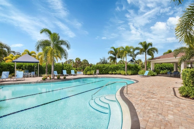 community pool with a gazebo and a patio area