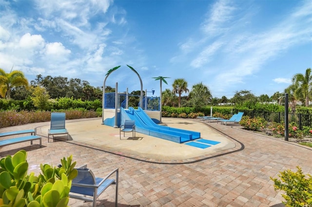 view of jungle gym featuring fence and a patio