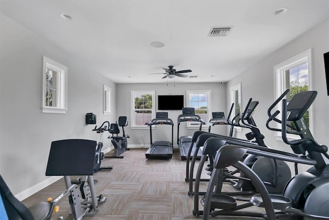 exercise room featuring baseboards, visible vents, and a ceiling fan