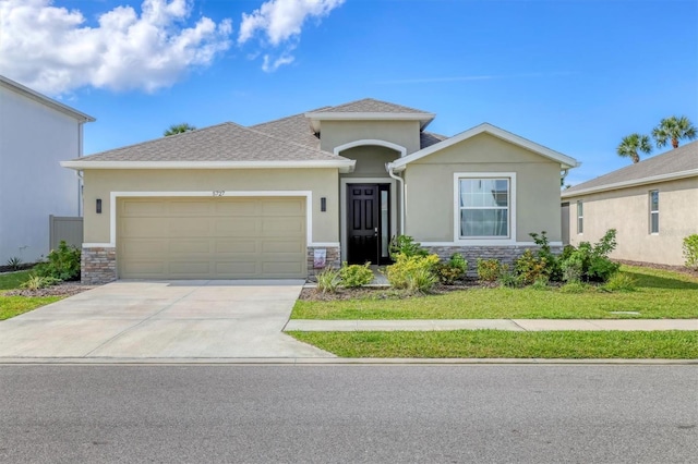 view of front of home with stucco siding, concrete driveway, a front yard, a garage, and stone siding