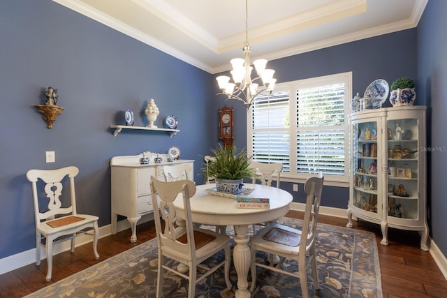 dining area featuring a tray ceiling, wood-type flooring, baseboards, and a chandelier