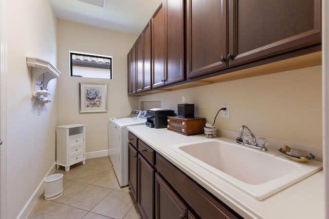 laundry area with baseboards, washer and clothes dryer, light tile patterned floors, cabinet space, and a sink