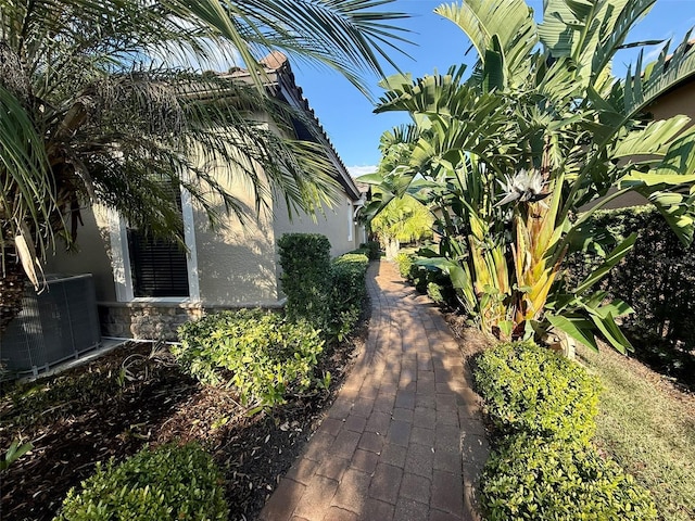 5031 Serata Dr, Bradenton, FL 34211 - view of side of home featuring stone siding, cooling unit, and stucco siding