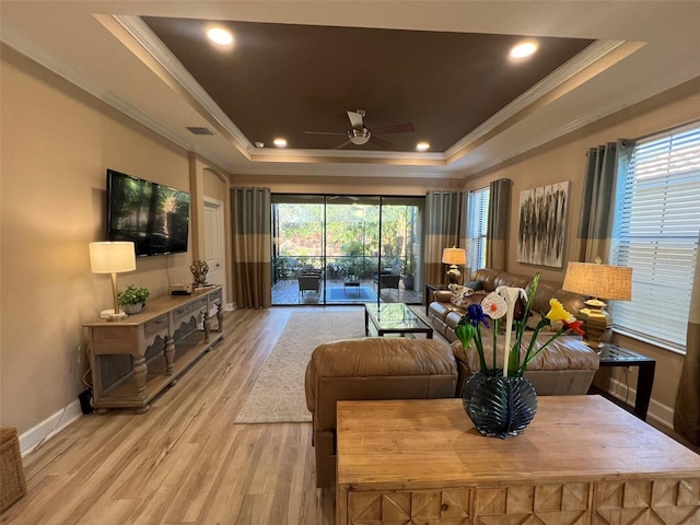 5031 Serata Dr, Bradenton, FL 34211 - living room with light wood finished floors, baseboards, a tray ceiling, and ornamental molding