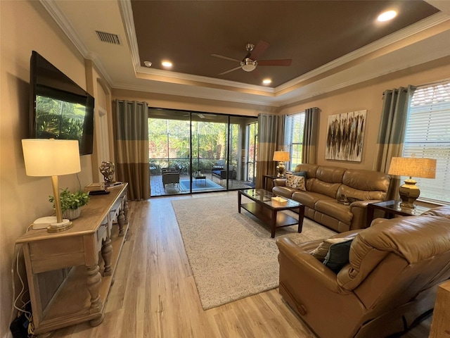 5031 Serata Dr, Bradenton, FL 34211 - living area featuring visible vents, a raised ceiling, a ceiling fan, crown molding, and light wood-type flooring