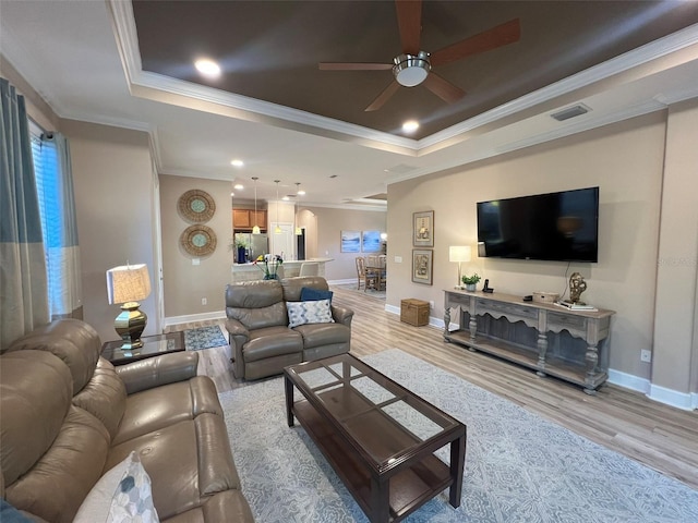 5031 Serata Dr, Bradenton, FL 34211 - living area with visible vents, a tray ceiling, and light wood-style flooring
