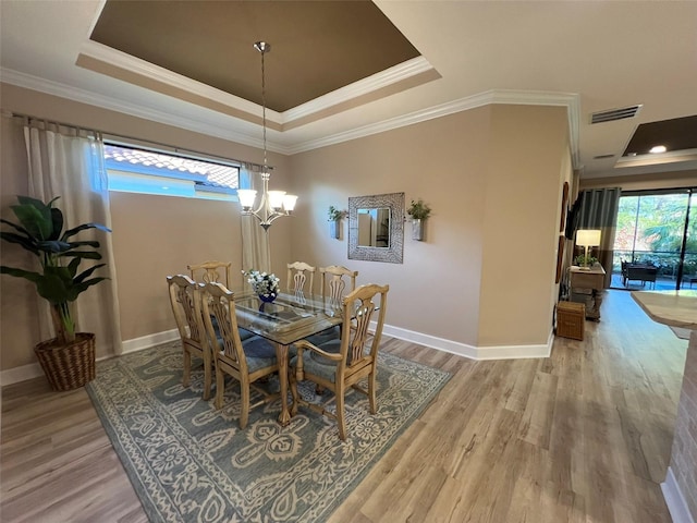 5031 Serata Dr, Bradenton, FL 34211 - dining area featuring a chandelier, a tray ceiling, wood finished floors, and visible vents