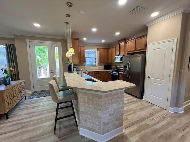 5031 Serata Dr, Bradenton, FL 34211 - kitchen featuring stainless steel appliances, visible vents, brown cabinetry, a sink, and a peninsula