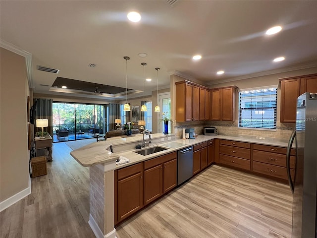 5031 Serata Dr, Bradenton, FL 34211 - kitchen featuring appliances with stainless steel finishes, brown cabinetry, open floor plan, a sink, and a peninsula