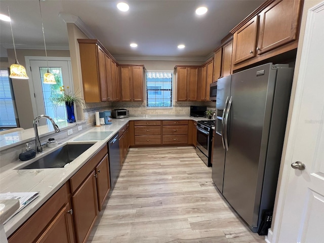 5031 Serata Dr, Bradenton, FL 34211 - kitchen featuring appliances with stainless steel finishes, brown cabinets, ornamental molding, a sink, and backsplash