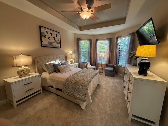 5031 Serata Dr, Bradenton, FL 34211 - bedroom featuring light carpet, a raised ceiling, a ceiling fan, and baseboards