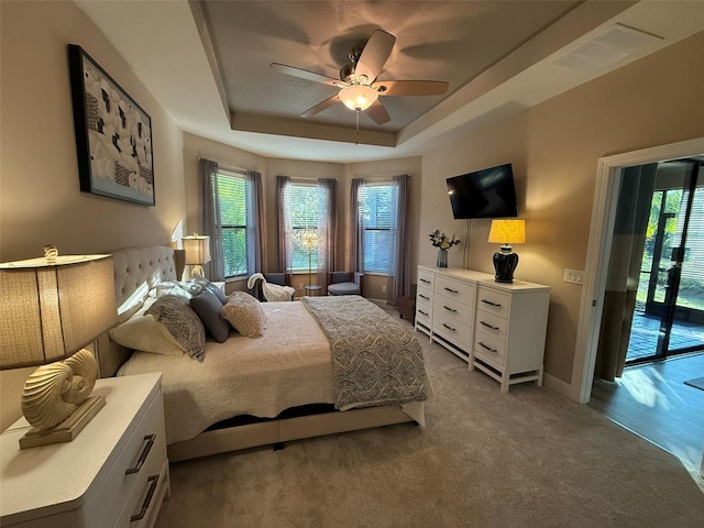 5031 Serata Dr, Bradenton, FL 34211 - bedroom with access to outside, a tray ceiling, multiple windows, and visible vents