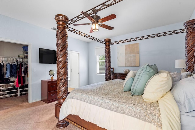 bedroom with light colored carpet, a ceiling fan, visible vents, a spacious closet, and a closet