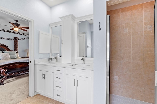 ensuite bathroom featuring a stall shower, connected bathroom, a ceiling fan, tile patterned flooring, and a sink