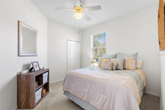 carpeted bedroom with a ceiling fan, a closet, and baseboards