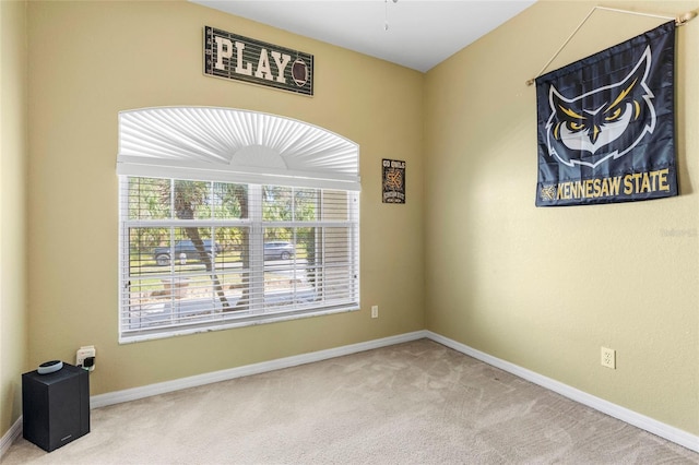 carpeted spare room with baseboards