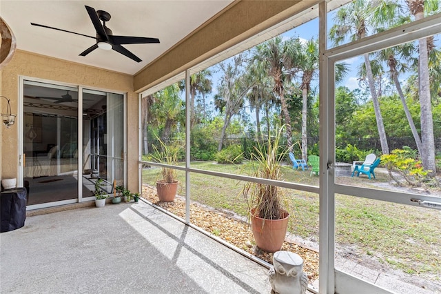 unfurnished sunroom with a ceiling fan