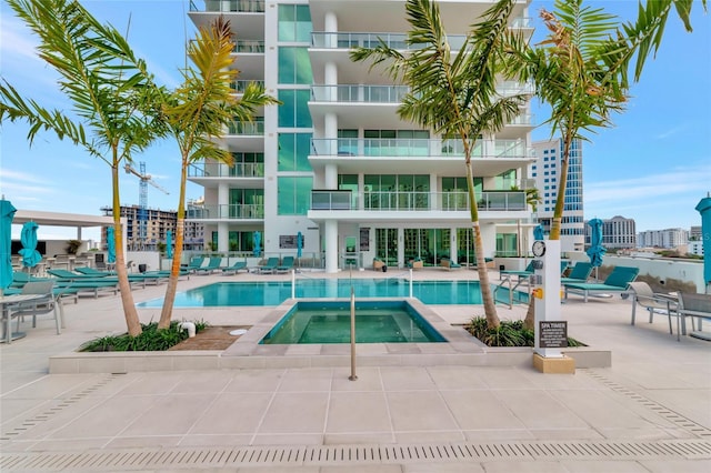 community pool featuring a patio area and a hot tub